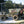 mobi road with a  dump truck being used outdoors with a forest in the background