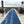 Photograph of an Australian beach that has a blue Mobi-Mat running down to the sea with a Mobi-Fence running along each side of the Mobi-Mat. Sea in the distance. Sand in the foreground.  