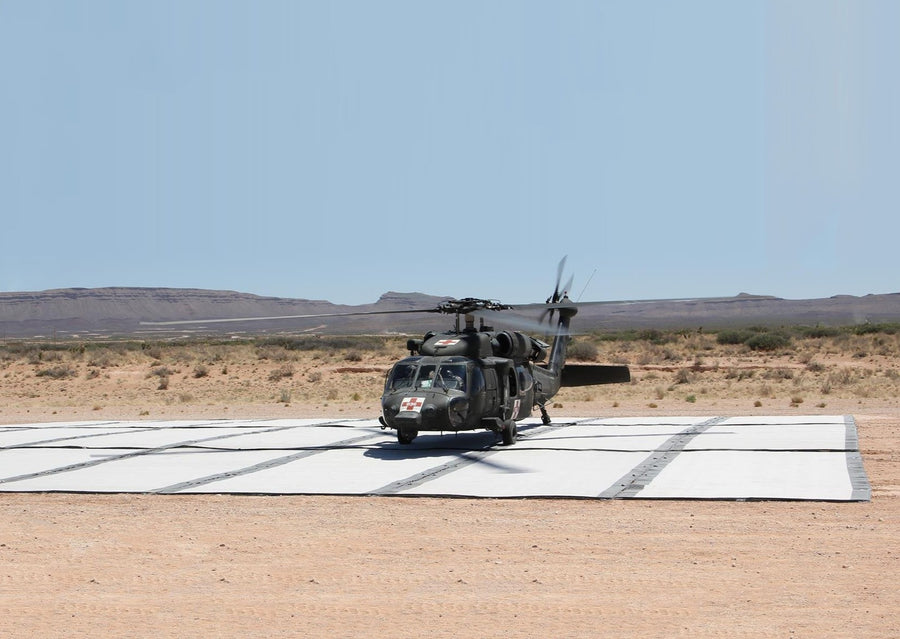 Photo of a military helicopter that has landed on a Mobi-Heli Portable helipad that has been deployed in the outback. 