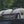 Photograph of a white Mobi-Track mat rolled up and tied to the roof racks of a car 